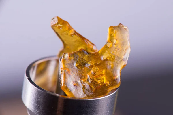 Piece of cannabis oil concentrate aka shatter on a titanium dab — Stock Photo, Image