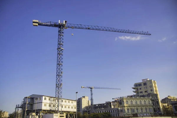 Construction cranes rise over typical colonial architecture in O — Stock Photo, Image