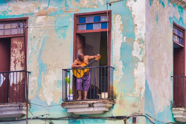 La Habana, Cuba - DIC 4, 2015: Escena urbana con músico en el balcón del edificio de La Habana Vieja , — Foto de Stock