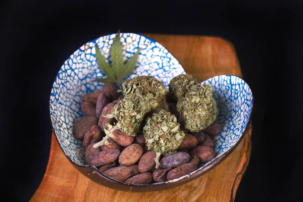 Gedroogde cannabis nugs met cacao bonen op een houten dienblad — Stockfoto