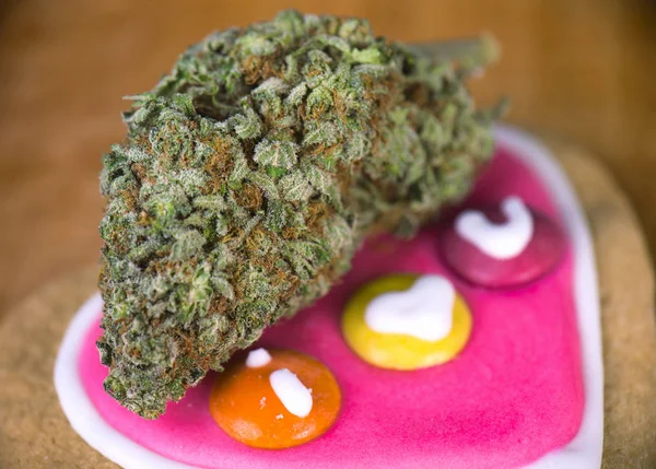 Dried cannabis nug with baked cookies on a wood tray — Stock Photo, Image
