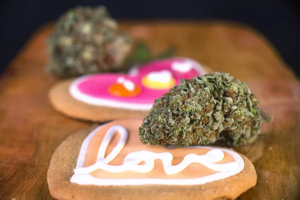 Nug de cannabis seco com biscoitos assados em uma bandeja de madeira — Fotografia de Stock