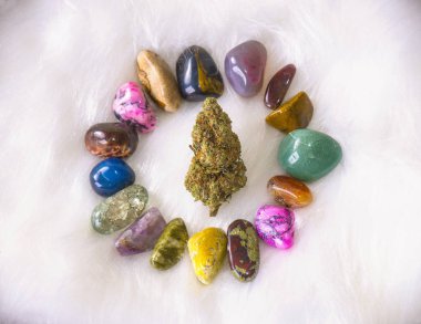 Cannabis bud (sour tangie strain) isolated on white with colorful geodes - Medical marijuana concept background clipart