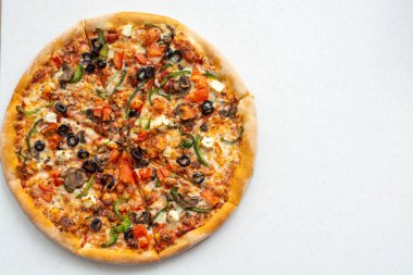 Beyaz arka planda domatesli, mozarellalı, mantarlı, zeytinli, kırmızı biberli ve fesleğenli lezzetli pizza. Kopyalama alanı.