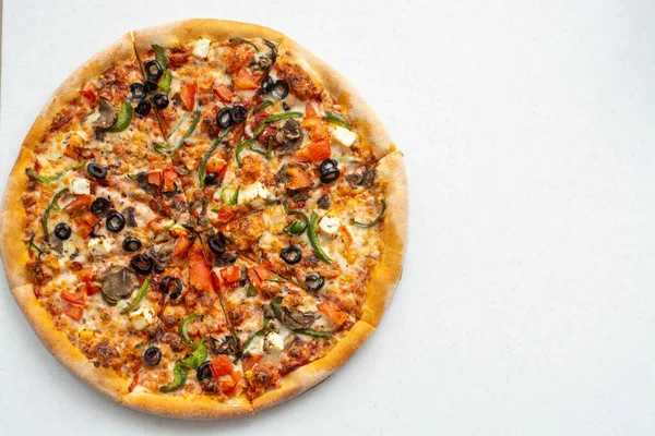 Beyaz arka planda domatesli, mozarellalı, mantarlı, zeytinli, kırmızı biberli ve fesleğenli lezzetli pizza. Kopyalama alanı.