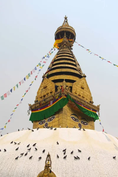 Close up view of the gold colored top of buddhist Swayambhunath stupa, also known among tourists as Monkey Temple, with traditional \
