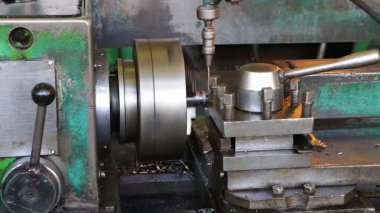 Eski bir torna torbasında, kırıntılar metal bir parçadan alınır. Su soğutmak için yukarıdan atölyeye dökülüyor. Yakın plan.