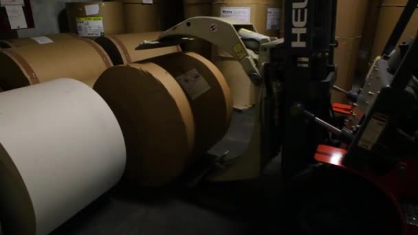 Автопогрузчик разгружает большой рулон бумаги — стоковое видео