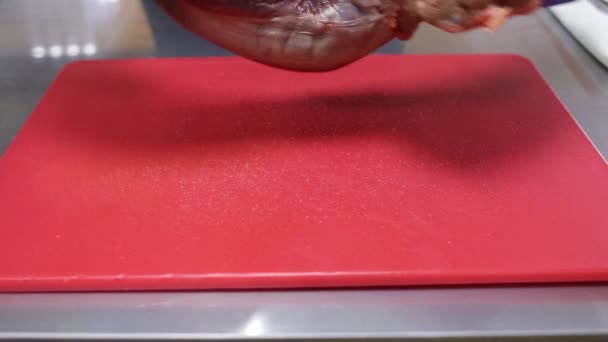 一个戴着蓝色手套的厨师把生肉放在一块红色的切菜板上 然后把它翻过来 后续行动 — 图库视频影像