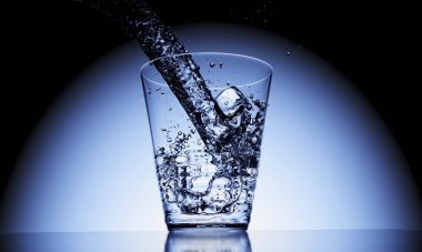 Üç boyutlu cam üzerine dökme suyu ve masa yüzeyinde yansıma ile buz küpü.