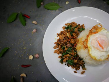 Üzerine kızarmış yumurta, kızarmış domuz eti ve fesleğen.