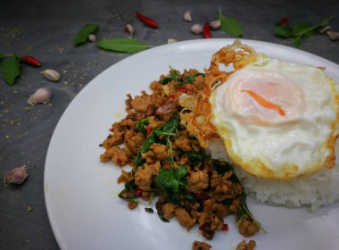 Üzerine kızarmış yumurta, kızarmış domuz eti ve fesleğen.