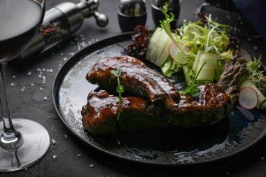 Siyah arka planda soslu dana kaburgası. 
