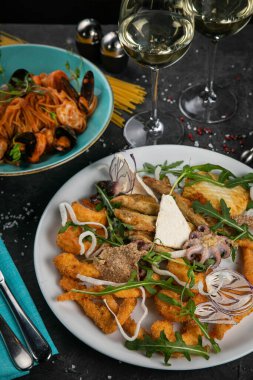 Koyu bir arka planda bir dizi deniz ürünü.