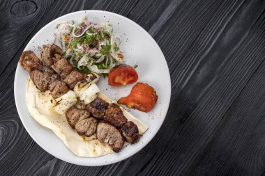 Siyah arka planda et ve pide.