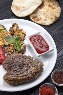 Etli biftek, sebze ve soslu.