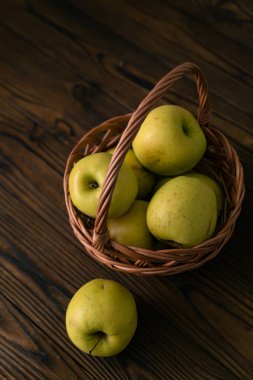 Kahverengi bir masada yeşil elmalar