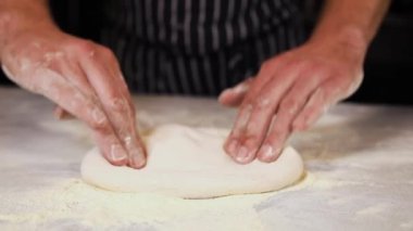 Aşçı restoranda pizza hamuru hazırlar.