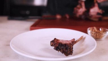 Şef kırmızı mutfak tahtasında et dilimliyor.