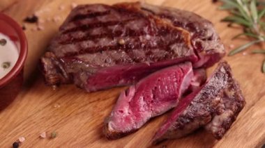 Ahşap bir tahtanın üzerinde soslu ve baharatlı biftek.