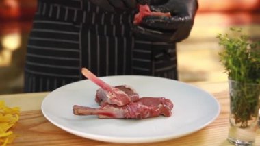 Aşçı tabağa çiğ et koyar.