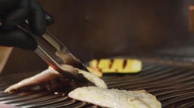 Aşçı ızgarada Dorada 'yı hazırlıyor.