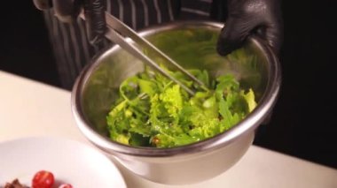 Şef et ve bitkilerle bir salata hazırlar.