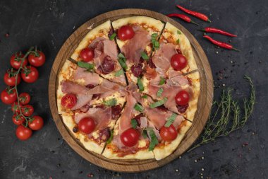 Siyah arka planda domatesli İtalyan pizzası.
