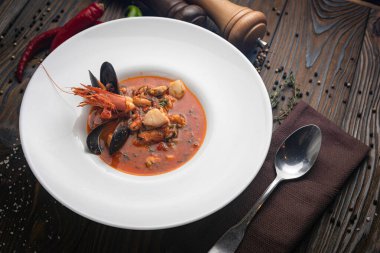 Tahta arka planda beyaz bir tabakta deniz mahsullü Tayland yer elması çorbası.