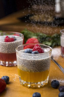 Böğürtlenli mango mus ve ahşap bir masada pudra şekeri.