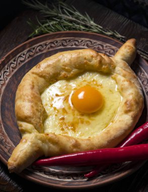 Misafirperver Gürcü mutfağı. Ahşap bir arka planda peynir ve yumurtalı Khachapuri.