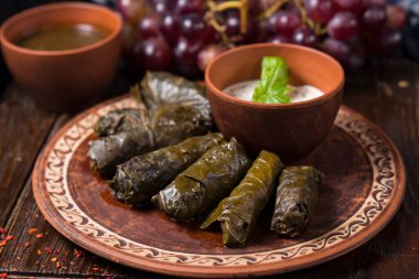 Etnik plaka ve ahşap arka planda Gürcü dolması. Gürcistan mutfağı