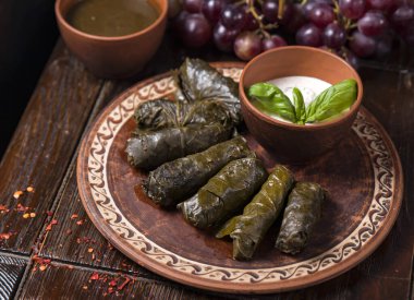 Etnik plaka ve ahşap arka planda Gürcü dolması. Gürcistan mutfağı