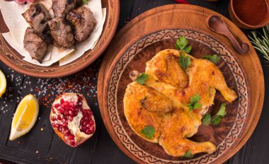 Etnik tabakta yeşillikli ızgara tavuk. Gürcistan mutfağı