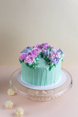  Düğün için güllü leziz kremalı pasta, cam tezgahta doğum günü. Güzel, modaya uygun turkuaz pasta pembe arka planda dekoratif elementlerle..