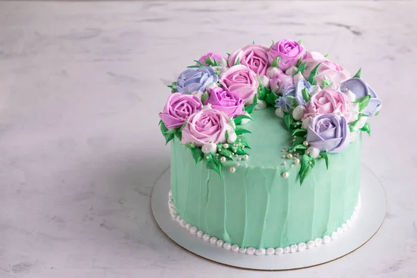 Tasty cake with cream roses for wedding, birthday. Beautiful, fashionable cake. Turquoise on a marble table. Copy space. — Stock Photo, Image
