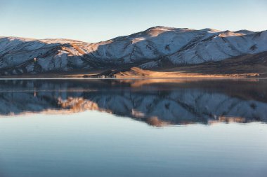Sakin Moğol gölündeki ayna yansıması. Rüzgarsız sabah ışığı. Batı Moğolistan