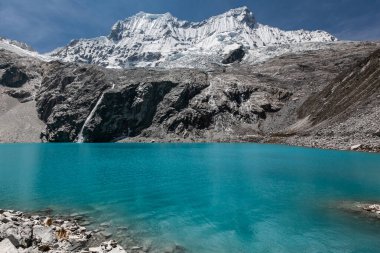 69 numaralı gölün turkuaz suyuna yürüyüş Peru 'nun karla kaplı ve Cordillera Blanca kayalık arazisi