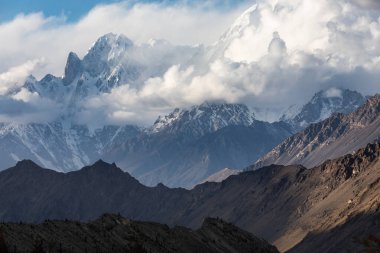 Karakoram sıradağları Rush Gölü 'ne doğru yol alıyor. Pakistan' ın kuzey bölgelerinde bulutlu bir gün.