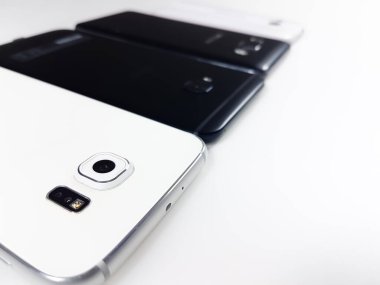 Ön planda ve odaklanmış dört akıllı telefonun perspektif görüntüsü ilk akıllı telefonun kamerasına odaklanmış..