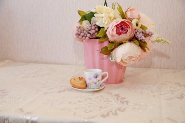 Bir fincan süt, kahve ve çiçek.