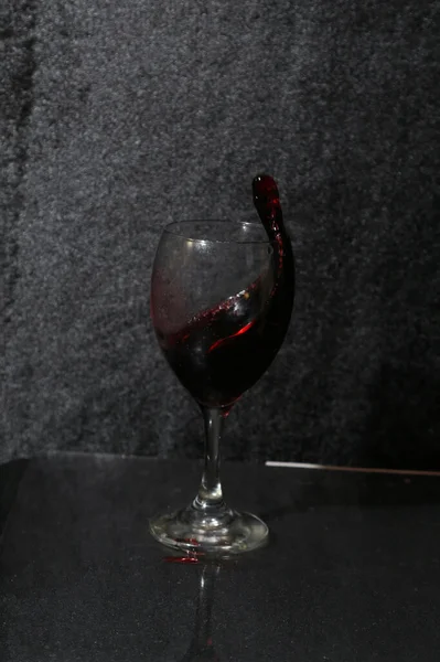 Een Glas Wijn Spat Een Zwarte Achtergrond Stockfoto