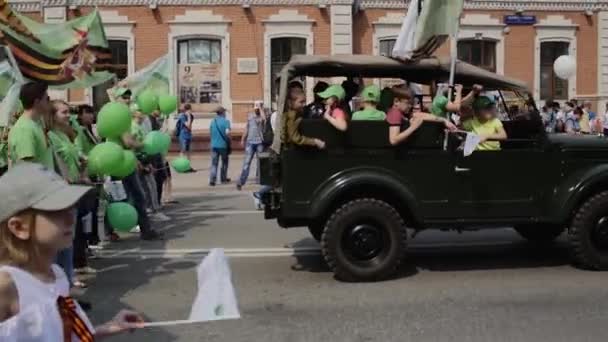 Jeep militar niños a bordo paseos calle de la ciudad 9 de mayo celebración del Día de la Victoria — Vídeos de Stock