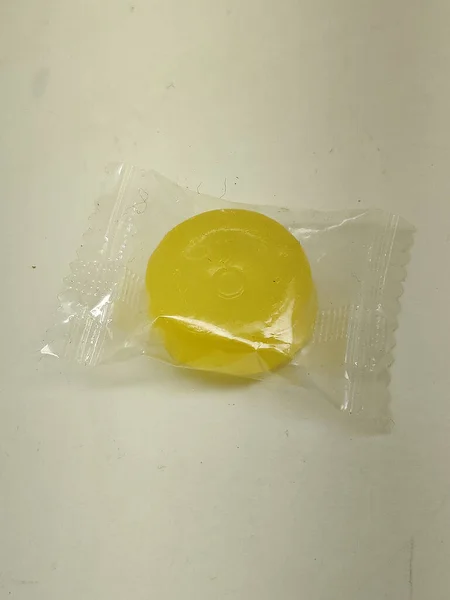 Doce Amarelo Embalado Invólucro Transparente Sobre Fundo Branco Brilhante Conceito — Fotografia de Stock