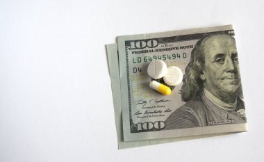 Beyaz arka planda haplar olan para. Bozuk paralar ve haplarla dolarlar