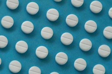 Mavi arka planda bir sürü hap var. tıp konsepti veya geçmişi