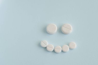 İyi tıp kavramı. Mavi arka planda haplardan oluşan mutlu yüz