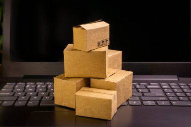 İnternet alışveriş konsepti. Küçük teslimat kutuları, dizüstü bilgisayarın üzerinde durun. Boşluğu kopyala