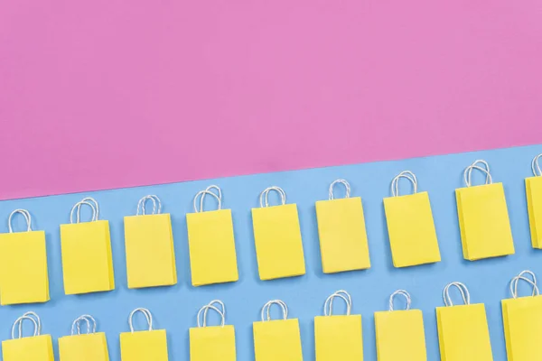 Muchas Bolsas Amarillas Sobre Fondo Rosa Azul Espacio Copia Concepto — Foto de Stock