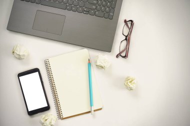 Yeni fikirler. kopya alanı, kağıt topları, samrtphone, laptop, kalem içeren dizüstü bilgisayar.